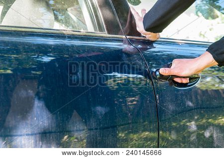 Caucasian Thief Hand Trying To Open A Car Door, Visible  Silhouette Of The Thief .