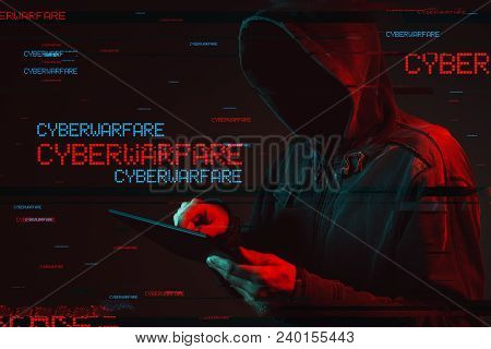 Cyberwarfare Concept With Faceless Hooded Male Person, Low Key Red And Blue Lit Image And Digital Gl