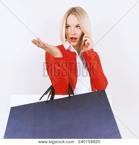 Portrait Of Young Woman In A Red Jacket With Shopping Bags On A White Background. Woman With Shoppin