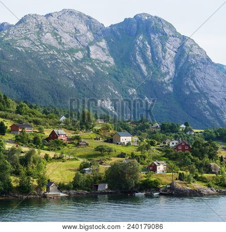 View of Jondal Commune and Hardangerfjord Fjord, Norway. Summer landscape with a Scandinavian village. Sunny weather