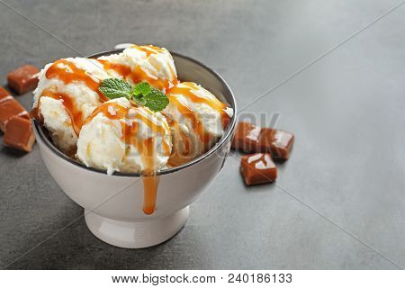 Tasty Ice Cream With Caramel Sauce In Bowl On Table
