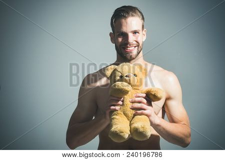 Young Sexy Attractive Guy With Toy Bear. Handsome Man With His Teddy Bear. Smiling Bearded Man Holdi