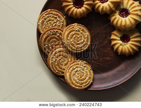 Biscuits Or Coocies With Jam And Sesame On Dark Plate On Beige Background, Top View, Copy Space