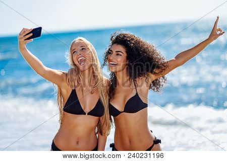 Two Women Taking Selfie Photograph With Smartphone In The Beach