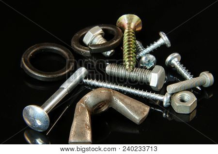 A Many Screws, Bolts, Washers, Nails And Nuts On Black Background