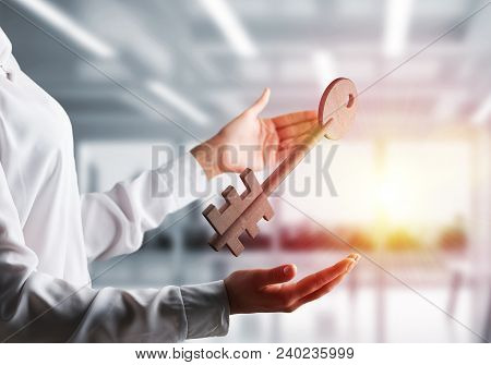 Business Woman In White Shirt Keeping Big Stone Key In Hands With Office View And Sunlight On Backgr