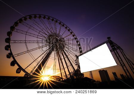 Blank Billboard With Silhouette Of Ferris Wheel At Sunset
