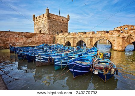 Fort Of Essaouira In Morocco On A Sunny Day With Blue Boats On The Water And Selective Focus
