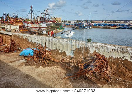 Port Of Essaouira In Morocco With Local Fishing Boats, Seagulls And Fishing Nets On A Sunny Day Soft