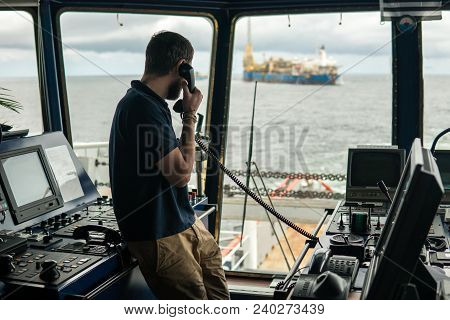 Deck Navigation Officer On The Navigation Bridge. He Speaks By Vhf Radio, Gmdss Watchkeeping, Collis