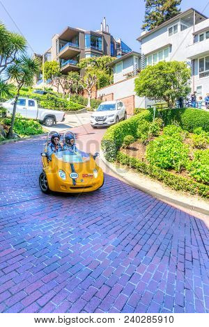 San Francisco - Apr 2, 2018: Tourists Drive Down Crooked Lombard Street On A Gocar, A Scooter Create