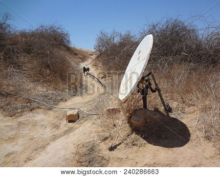 Satellite Dish With Actuator, In The Desert Of Tunisia. Unusual Antenna Installationin The Sands Of 