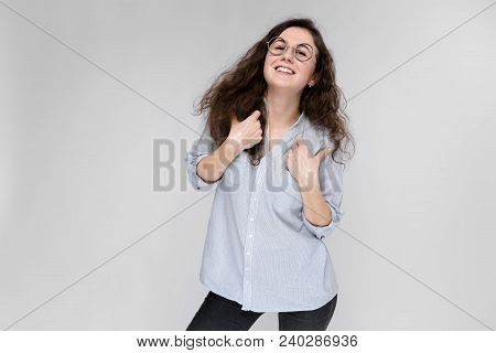 Young Girl With Glasses On A Gray Background. Portrait Of A Young Beautiful Girl. A Charming Girl In
