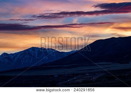 The Snow-capped Rocky Mountains At Sunset Or Sunrise With A Beautifully Colorful Sky
