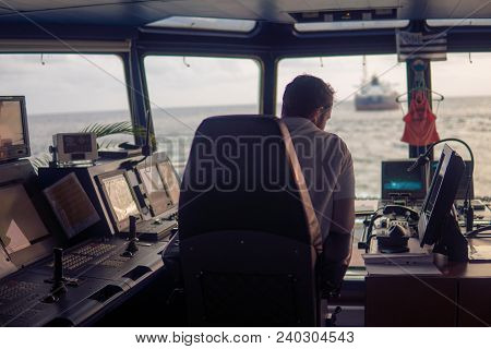 Deck Navigation Officer On The Navigation Bridge. He Looks At Radar Screen. Watchkeeping, Collision 