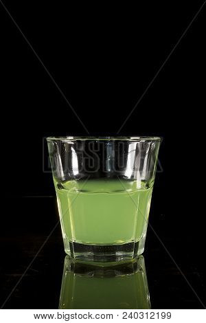 A Glass With Absinth On A Black Reflecting Surface