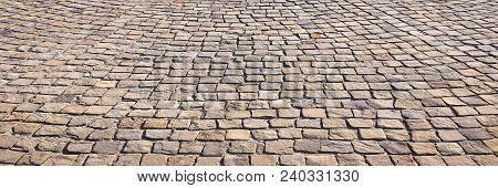 Stone Pavement In Perspective. Stone Pavement Texture. Granite Cobblestoned Pavement Background. Abs