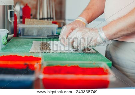Professional Chef, Chef The Process Of Making Sushi Rolls, Spins Bamboo Mat And Cut Slices