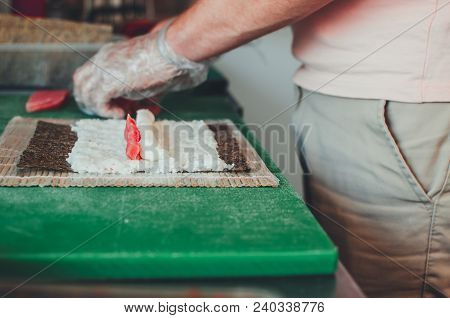 Professional Chef, Chef The Process Of Making Sushi Rolls, Spins Bamboo Mat And Cut Slices