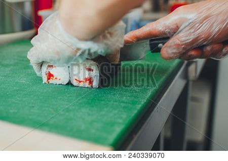 Professional Chef, Chef The Process Of Making Sushi Rolls, Spins Bamboo Mat And Cut Slices