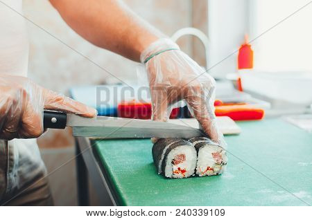 Professional Chef, Chef The Process Of Making Sushi Rolls, Spins Bamboo Mat And Cut Slices