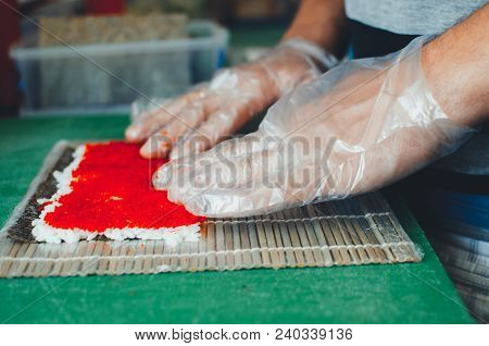 Professional Chef, Chef The Process Of Making Sushi Rolls, Spins Bamboo Mat And Cut Slices