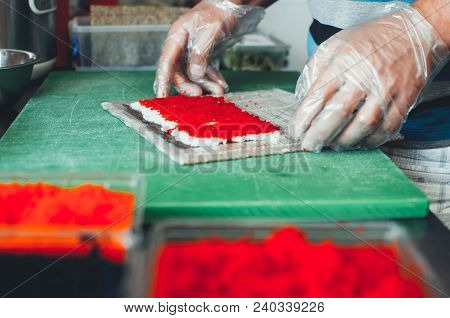 Professional Chef, Chef The Process Of Making Sushi Rolls, Spins Bamboo Mat And Cut Slices