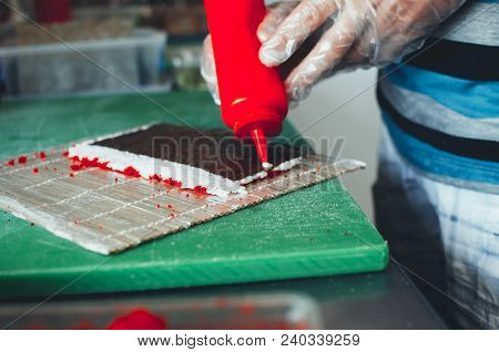 Professional Chef, Chef The Process Of Making Sushi Rolls, Spins Bamboo Mat And Cut Slices