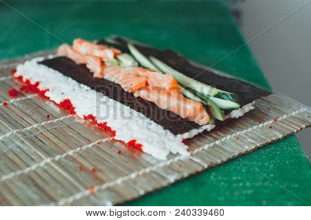 Professional Chef, Chef The Process Of Making Sushi Rolls, Spins Bamboo Mat And Cut Slices