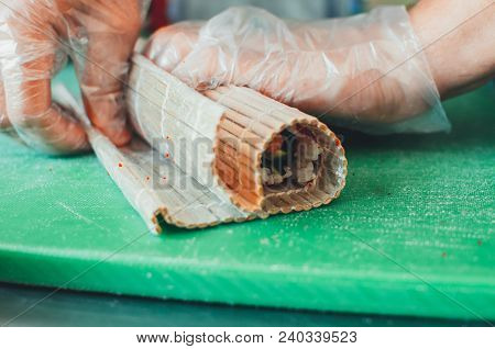 Professional Chef, Chef The Process Of Making Sushi Rolls, Spins Bamboo Mat And Cut Slices