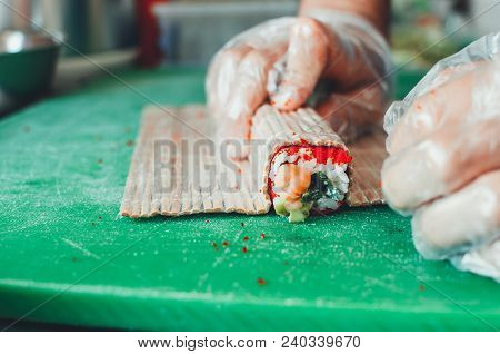Professional Chef, Chef The Process Of Making Sushi Rolls, Spins Bamboo Mat And Cut Slices