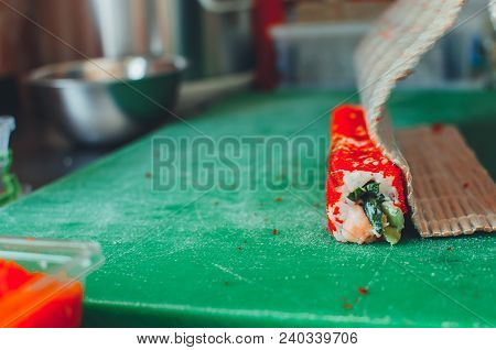 Professional Chef, Chef The Process Of Making Sushi Rolls, Spins Bamboo Mat And Cut Slices