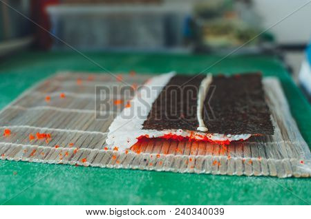 Professional Chef, Chef The Process Of Making Sushi Rolls, Spins Bamboo Mat And Cut Slices