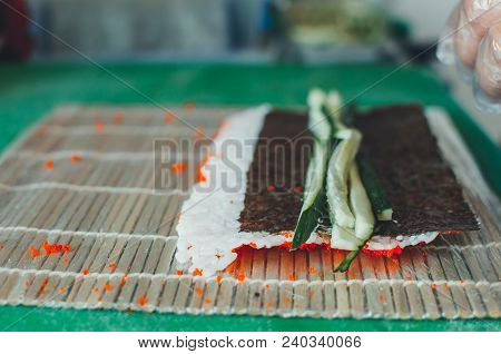 Professional Chef, Chef The Process Of Making Sushi Rolls, Spins Bamboo Mat And Cut Slices