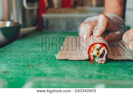 Professional Chef, Chef The Process Of Making Sushi Rolls, Spins Bamboo Mat And Cut Slices