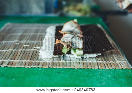 Professional Chef, Chef The Process Of Making Sushi Rolls, Spins Bamboo Mat And Cut Slices