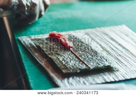 Professional Chef, Chef The Process Of Making Sushi Rolls, Spins Bamboo Mat And Cut Slices