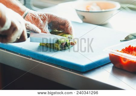 Professional Chef, Chef The Process Of Making Sushi Rolls, Spins Bamboo Mat And Cut Slices