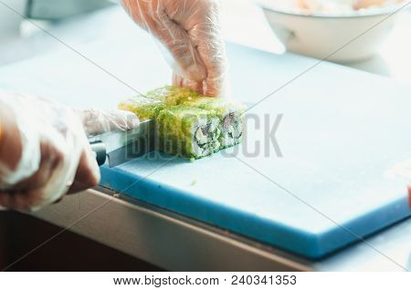 Professional Chef, Chef The Process Of Making Sushi Rolls, Spins Bamboo Mat And Cut Slices