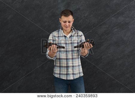 Young Guy Alcoholic With Headache Holding Bottle Of Beer. Sad Man Suffering From Hangover, Dark Stud