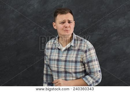 Suspicious Young Man Looks Doubtfully, Curves Lips, Being Indecisive, Makes Grimace, Tries To Find S
