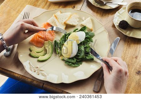 Healthy Breakfast - Poached Eggs With Smoked Salmon, Avocado, Spinach And Crusty Baguette. Woman Eng