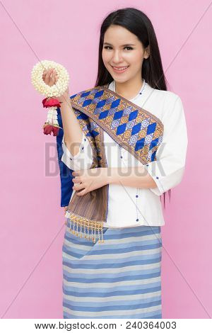 Portrait Of Asian Young Girl In Traditional Thai Dress And Holding Jasmine Garland Isolated On Pink