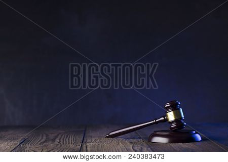 Law Theme. Mallet Of The Judge On Wooden Desk And Violet Background. Place Fort Ext.