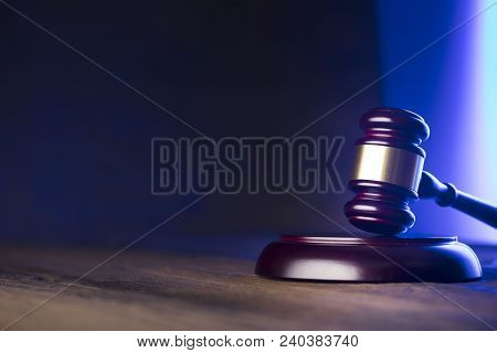 Law Theme. Mallet Of The Judge On Wooden Desk And Blue And Violet Background. Place Fort Ext.