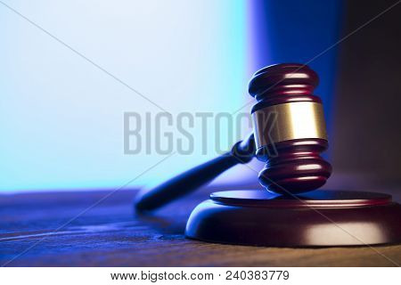 Law Theme. Mallet Of The Judge On Wooden Desk And Blue Background. Place Fort Ext.