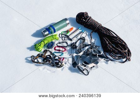 Close-up Of Winter Climbing Equipment On Fresh Snow On A Sunny Day. Carbines With A Rope Gazebo And 
