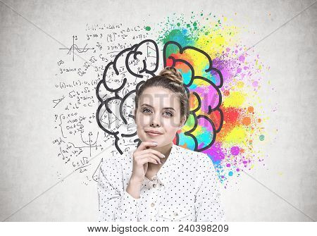 Portrait Of A Young Woman Wearing A White Dotted Shirt And Sitting With Her Hand On The Chin. She Is