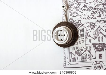 Household Electrical Socket With White Woven Wires Against A White Wall With A Pattern.