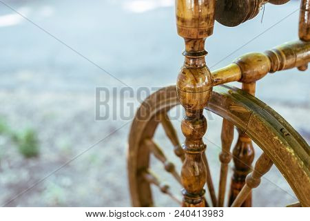 Old Spinning Wheel Stands In The Shade Of The Trees